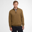 A person wearing a brown quarter-zip jumper over a plaid shirt, standing against a plain white background. The tone is neutral and relaxed.