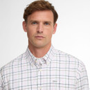 A man with short brown hair wears a white checkered shirt with pastel lines. He has a neutral expression against a plain white background.