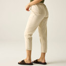 Rear view of model wearing cream cropped trousers with elasticated waist and back pockets.