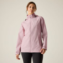 Woman wearing a light pink hooded waterproof jacket with a full-length zip and high collar, paired with black leggings.