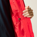 Close-up of the red waterproof jacket sleeve showing the adjustable waist drawcord and fabric detail.