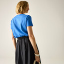 Back view of a woman wearing a plain blue short-sleeve T-shirt.
