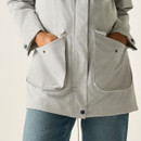 Close-up of front pockets on women’s light grey waterproof jacket.