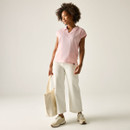 Women’s pink and white striped short-sleeve polo top, worn with light trousers.