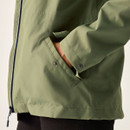 Close-up of a green jacket showing a front pocket with popper fastening and smooth fabric texture.
