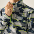 A person zips up a fuzzy, camo-patterned fleece with "Regatta Great Outdoors" logo. The design features gray, navy, and neon green hues.