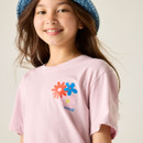 Smiling child in a pink T-shirt with colourful flower prints, wearing a blue hat, against a light background. The mood is cheerful and playful.