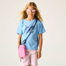 A young girl with long blonde hair wears pink tinted sunglasses and a blue butterfly-themed T-shirt. She carries a small pink crossbody bag.