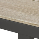 Close-up of wood-effect tabletop showing textured grain finish and dark grey metal table edge.