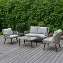 Outdoor lounge set with two-seat sofa, two rope woven armchairs and matching coffee table on a decking patio with greenery.