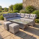 Grey rattan Florida rectangular corner garden furniture set with glass table and stools on stone patio