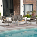 Modern outdoor patio furniture set by a pool, featuring a grey cushioned sofa, two matching chairs, and a table with a vase and cups.