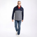 Model wearing a navy textured half-zip jumper with white stripe panel, styled with jeans and trainers.