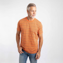 A man wearing an orange striped crew-neck T-shirt and blue jeans, looking to the side.