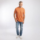 Full-body shot of a grey-haired male model wearing an orange striped T-shirt, blue jeans and white trainers against a white background.