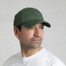 Model wearing an olive green twill baseball cap with embroidered fish logo on the front.