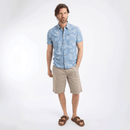 Full-length view of man in light blue printed short-sleeve shirt, beige shorts, and brown sandals.