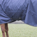 Close-up of navy Shires Typhoon turnout rug with adjustable belly surcingles and buckles.