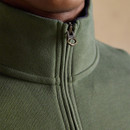 Close-up of the green fleece showing the quarter-zip fastening and raised collar with branded metal zip pull.