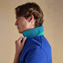 Side profile of model wearing the blue polo shirt with green contrast collar detail, holding the collar up.