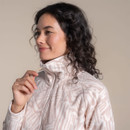 Close-up of a woman wearing a pale pink patterned fleece with the half-zip and high collar visible.