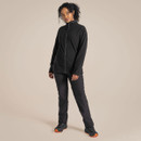 Full-length view of a model wearing a black fleece jacket with black walking trousers and hiking shoes.