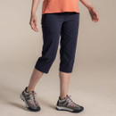 Model wearing navy women’s 3/4 length walking trousers with hiking shoes, side view.