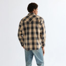 Back view of model wearing a beige and charcoal check western shirt with western yoke detail and light wash jeans.
