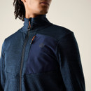 Close-up of navy midlayer jacket showing contrast chest panel, zip chest pocket and high collar.