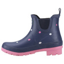Navy blue rubber ankle boot with pink and white polka dots, featuring a pink sole and heel. The design is playful and casual.