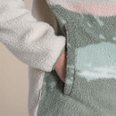 Detail of the side hand pocket on the women’s sherpa fleece pullover, showing borg texture and sage edge trim.