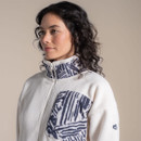 Close-up of cream fleece jacket showing navy patterned stand collar and matching chest pocket detail.