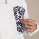 Close-up of navy patterned chest pocket on cream fleece jacket, showing the zip pocket opening.