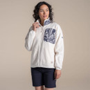 Model wearing a cream fleece zip-up jacket with navy patterned chest pocket and stand collar.