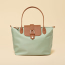 Sage green Joules tote bag with tan leather handles and trim, shown front-on against a beige background.