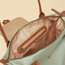 Open tote bag showing pink polka-dot lining and internal zip pocket inside the sage green Joules bag.