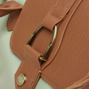 Close-up of the gold-tone Joules buckle on the tan leather flap of the sage green tote bag.