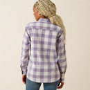 Back view of the model wearing the purple-and-white plaid long-sleeve shirt against a beige studio background.