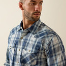 Close-up of the shirt’s collar, snap buttons, and chest pockets on the blue plaid fabric.