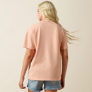 Rear view of the peach short-sleeve T-shirt showing a clean, unprinted back, paired with denim shorts on a neutral studio background.