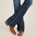 Close-up of the bootcut leg opening over brown leather western boots.