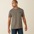 Model wearing a grey Ariat short-sleeve T-shirt with chest logo, paired with blue jeans, looking to the side.