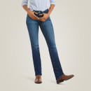 Front view of the model wearing dark-wash straight-leg jeans with a light blue button-up shirt tucked in and brown boots.