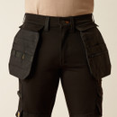 Front waist close-up highlighting the black utility pants’ detachable tool pouches, belt loops, and front fly area.