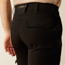 Back close-up of the waistband and rear pocket of the black pants, showing the Ariat brand patch and curved seam lines.