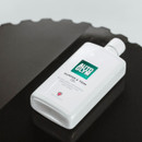 Autoglym Bumper & Trim Gel bottle lying on black plastic trim with a glossy restored finish.