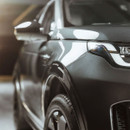 Close-up of a shiny grey car front wing and headlight showing a glossy finish.