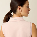 A woman with brown hair in a ponytail is shown from the back. She wears a sleeveless, pale pink shirt with "ARIAT" embroidered on the collar.