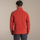 Rear view of a male model wearing the orange half-zip fleece, showing the fit across the back and collar branding.