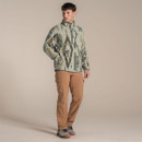 Male model standing in a studio wearing a light green patterned Craghoppers half-zip fleece with brown walking trousers.